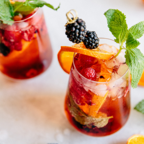 aperol spritz with berries and garnished with mint leaves