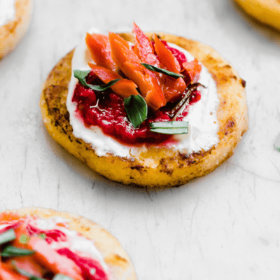 mini polenta cakes topped with salmon and raspberry sauce