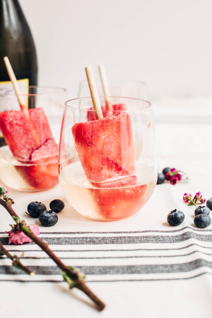 champagne strawberry popsicles dipped inside a glass of champagne