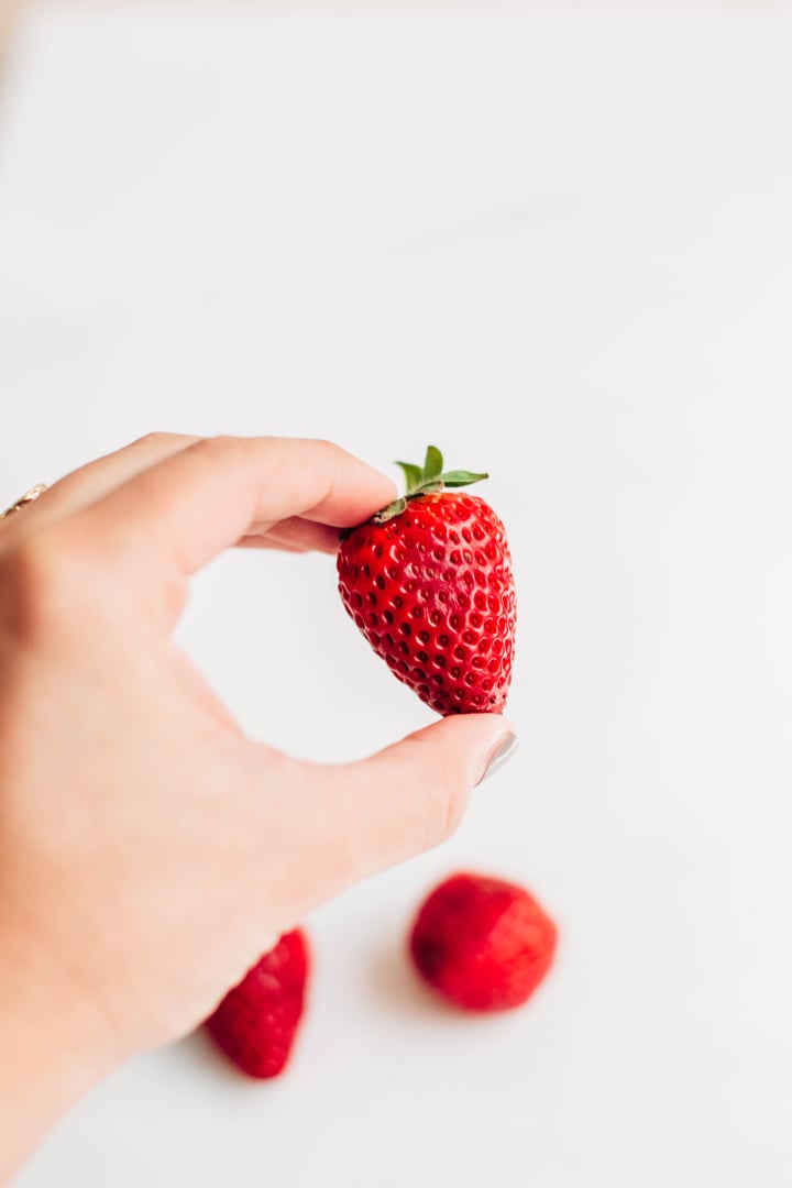 someone holding a strawberry