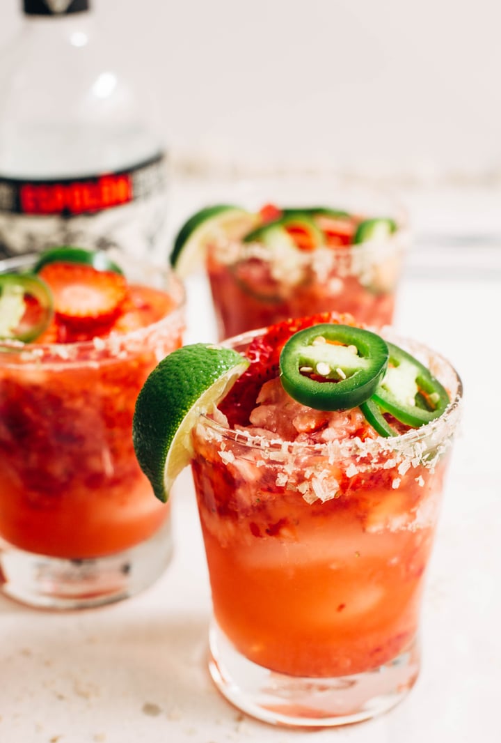 strawberry jalapeno margaritas in a glass with salted rim