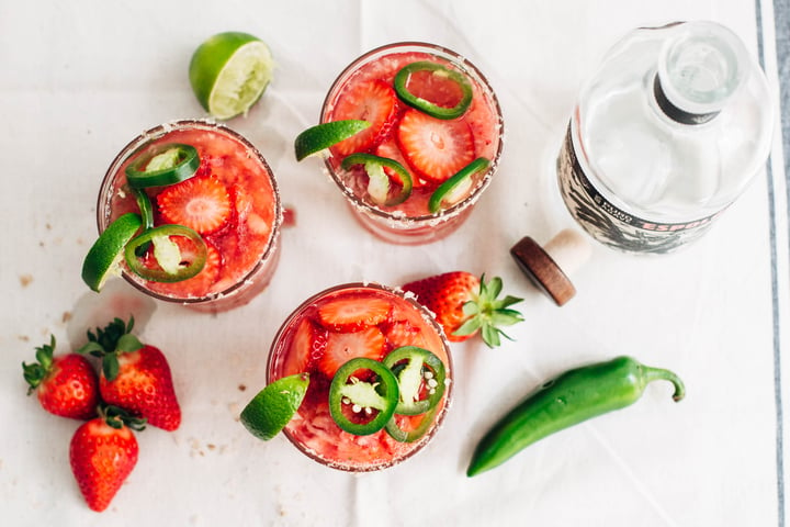 Above shot of strawberry jalapeno margaritas in a glass with salted rim