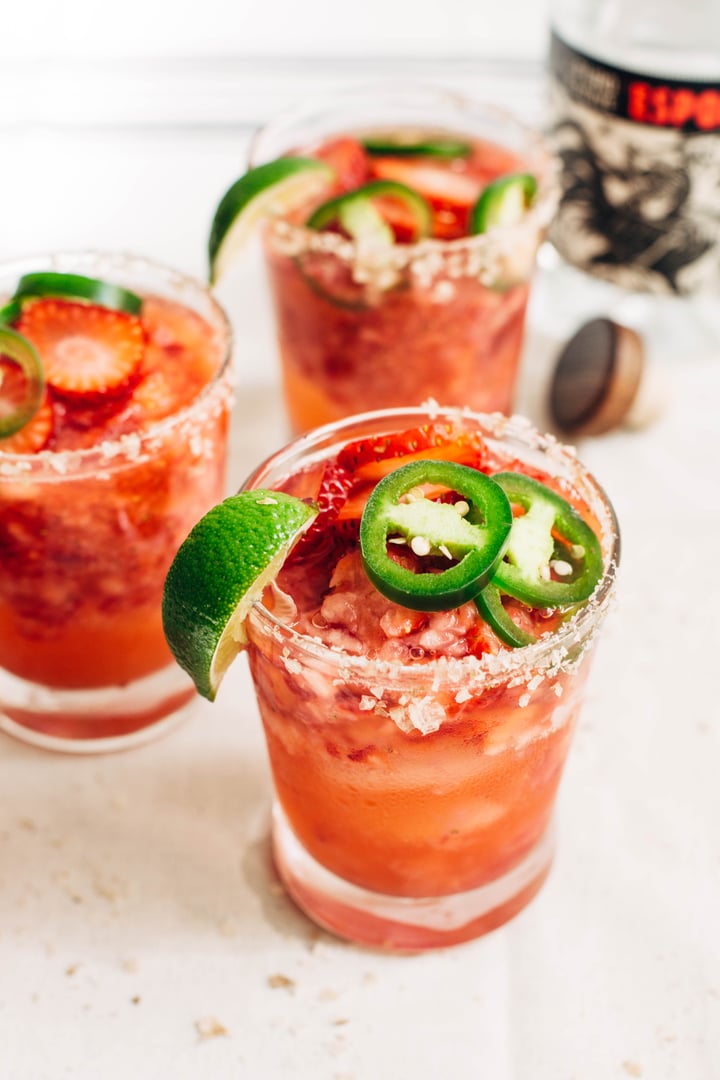 close up of strawberry jalapeno margaritas in a glass with salted rim