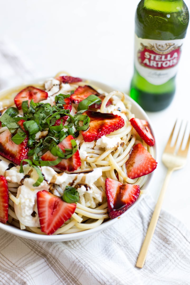 pasta topped with strawberries, cheese, and basil