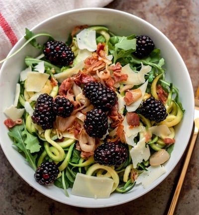 zoodle salad topped with blackberries