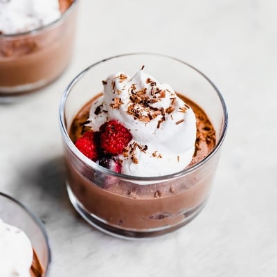chocolate mousse topped with whipped cream and berries