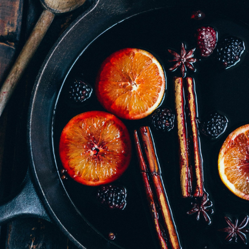 blackberry mulled wine with orange slices and cinnamon sticks