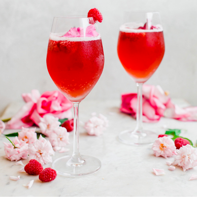raspberry paloma fizz topped with a pink flower and a raspberry 
