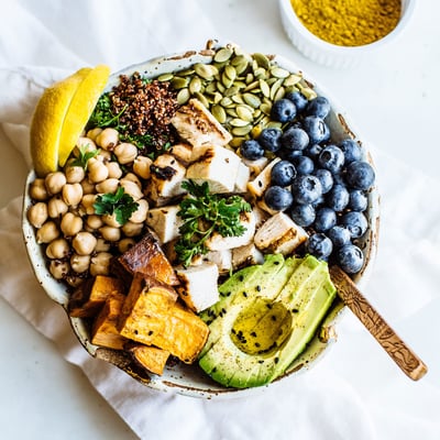 Bowl with grilled chicken, avocado, blueberries, garbanzo beans, and pumpkin seeds