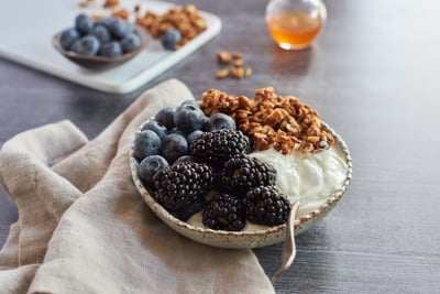 yogurt with blackberries, blueberries, and granola on the side