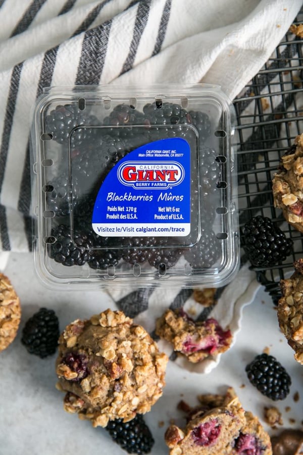 A California Giant Berry Farms blackberry clamshell with muffins surrounding it