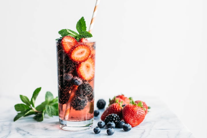 DIY Starbucks Refresher which contains berries and garnished with a mint leaf