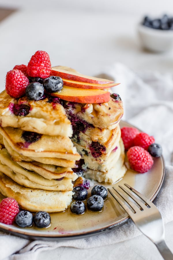 stack of blueberry pancakes topped with berries