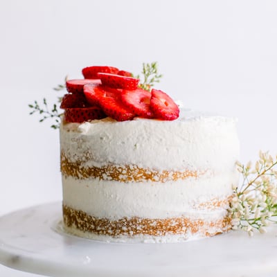 round cake with strawberries sliced on top 