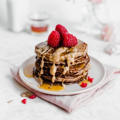 Stack of almond butter pancakes topped with raspberries