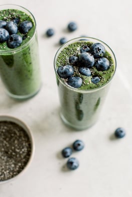 green smoothie topped with blueberries