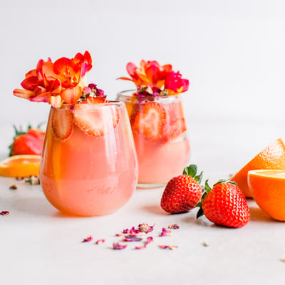 Strawberry Ginger Hibiscus Margarita garnished with sliced strawberries and flowers 