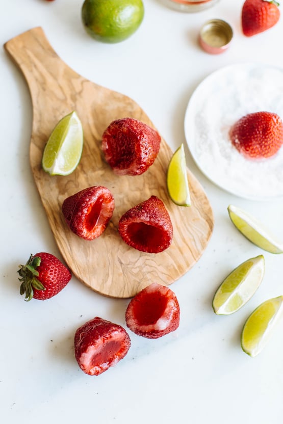 Hollow strawberries on a cutting board with a lime on the side