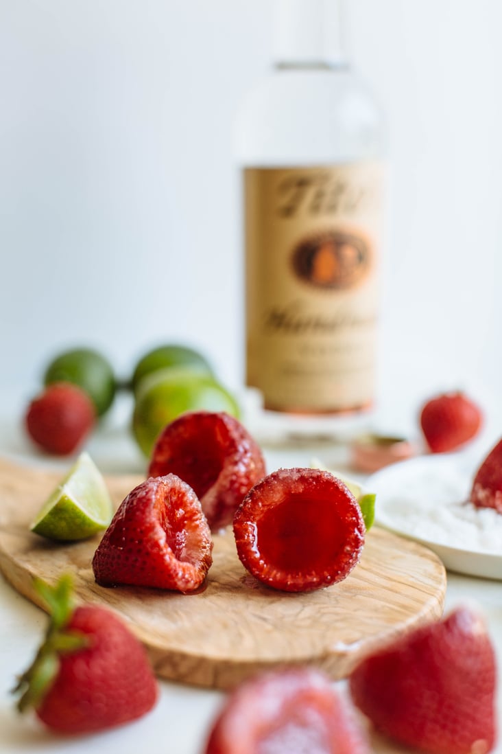 Hollow strawberries on a cutting board with a lime on the side