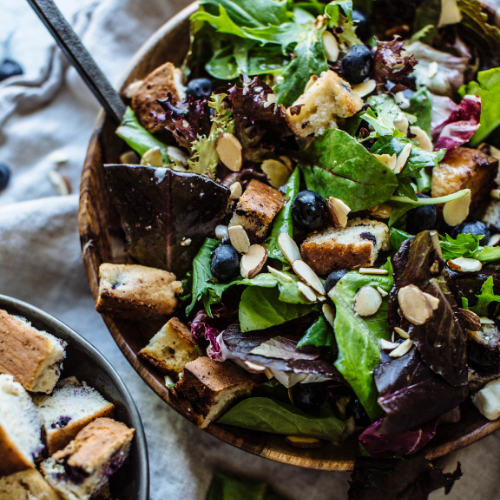 salad topped with blueberries and blueberry muffin croutons 