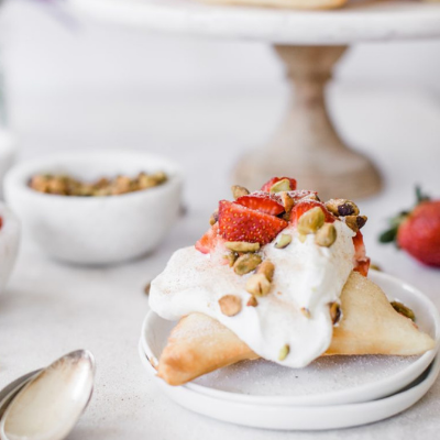 Sopapillas with whipped cream, strawberries, and pistachios