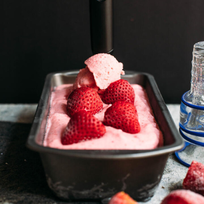 strawberry ice cream in a baking pan topped with strawberries