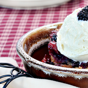 bowl of berry cobbler on a plaid tablecloth