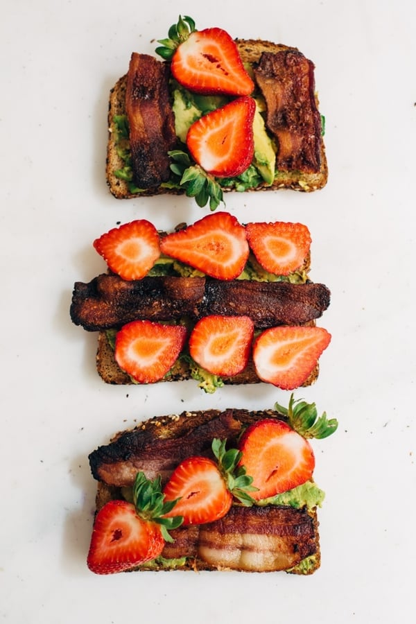 avocado toast topped with strawberries and bacon
