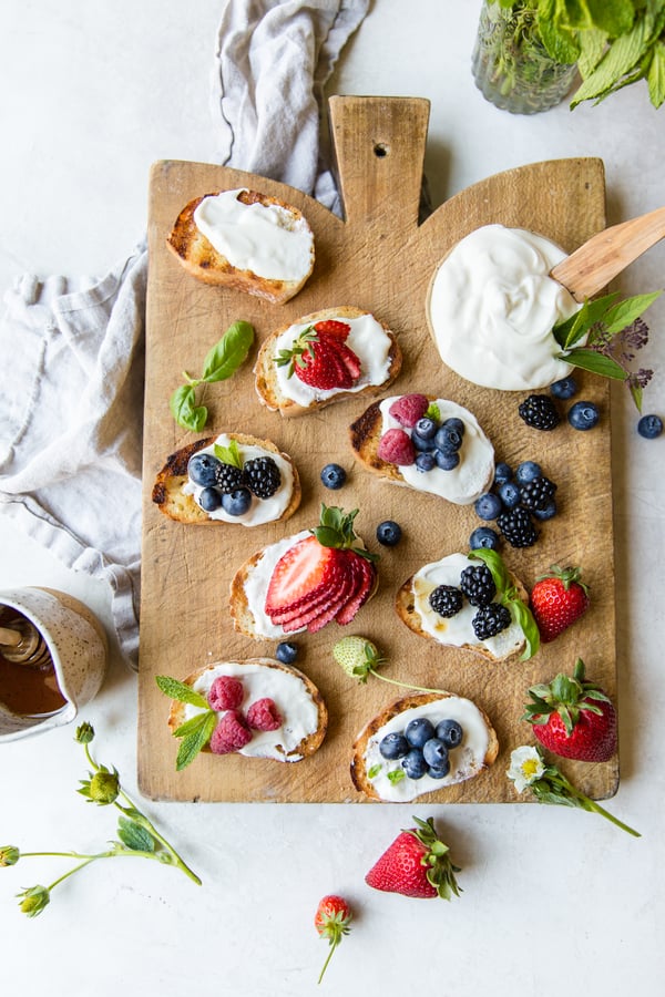 berry bruschetta topped with berries on a cutting board  