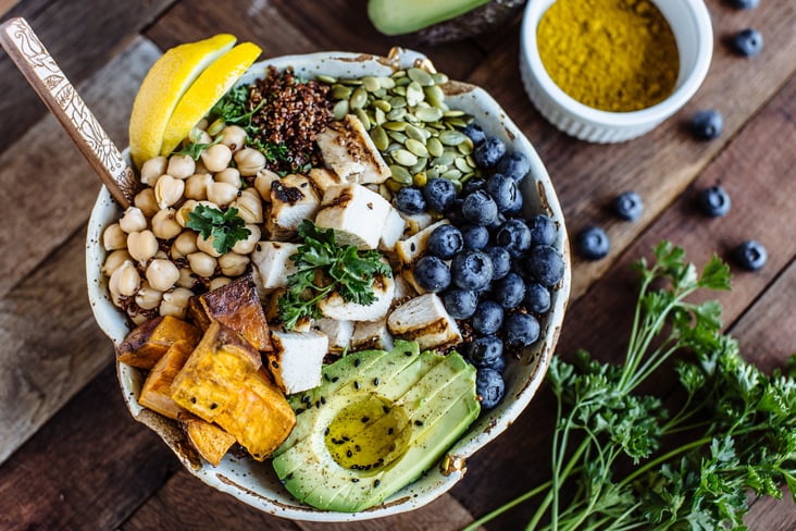 a bowl with avocado, blueberries, garbanzo beans, grilled chicken, and pumpkin seeds