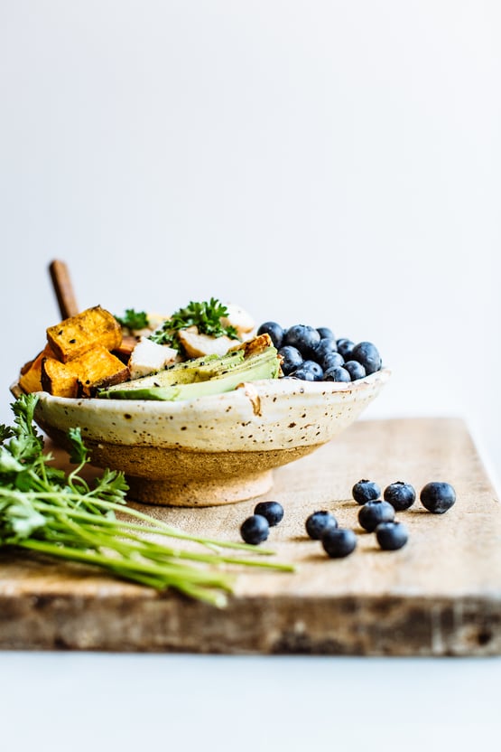 a bowl with avocado, blueberries, garbanzo beans, grilled chicken, and pumpkin seeds