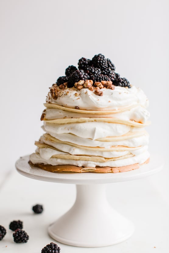 crepes topped with blackberries, whipped cream, and candied pecans