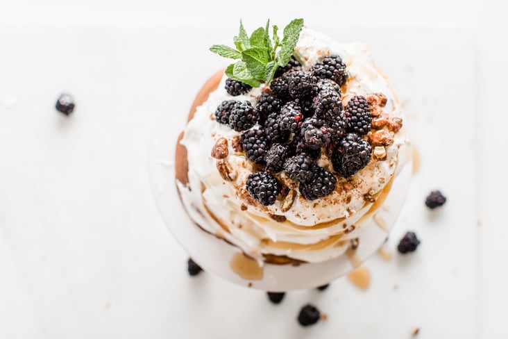 crepes topped with blackberries, whipped cream, and candied pecans