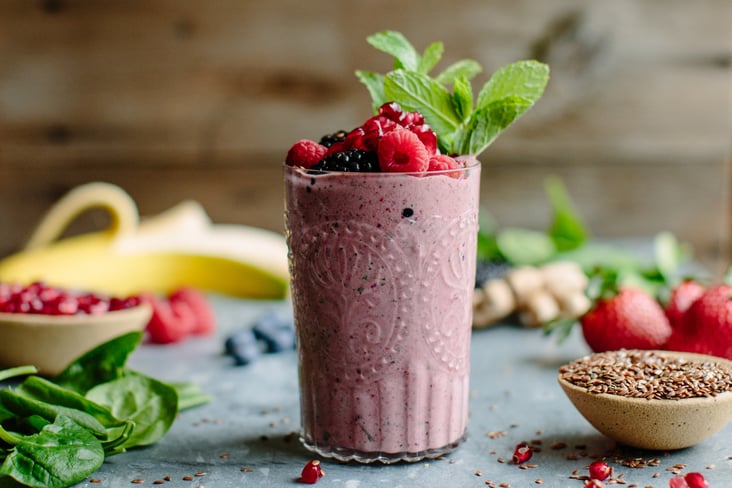 berry smoothie topped with berries and mint leaves