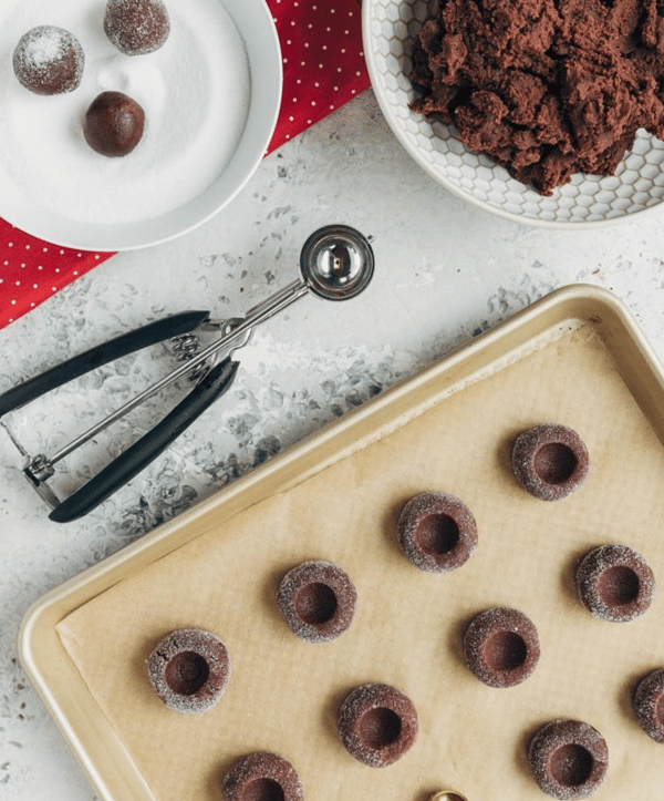 Chocolate Thumbprint Cookies with Raspberries on a baking sheet