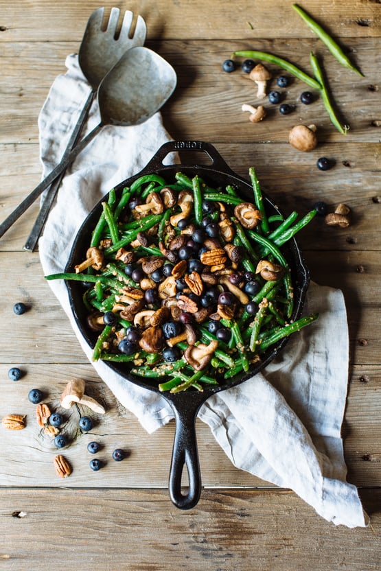 green beans with blueberries, shitake mushrooms, and pecans in a cast iron skillet