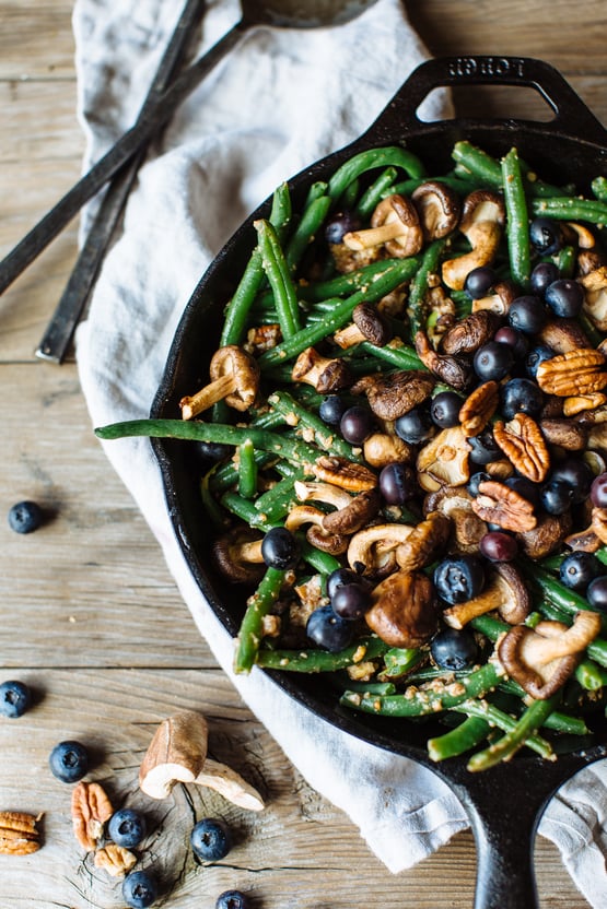 green beans with blueberries, shitake mushrooms, and pecans in a cast iron skillet