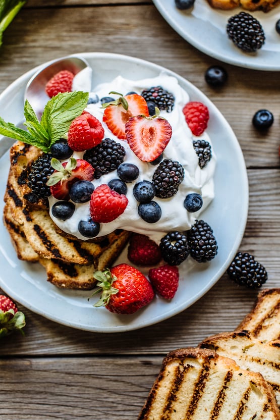 grilled pound cake topped with berries and whipped cream 