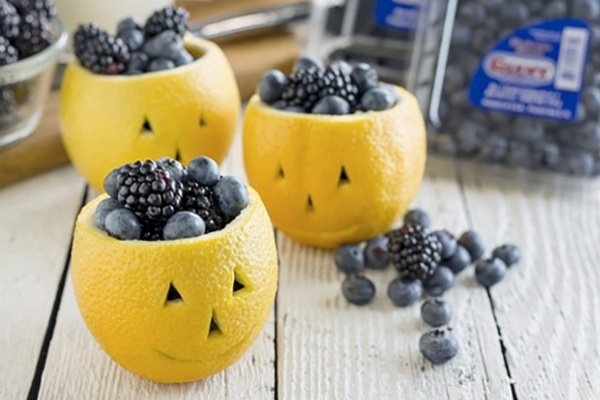 a lemon jack-o-lantern filled with berries