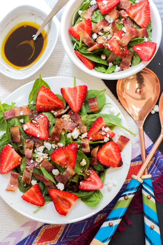 salad topped with strawberries and bacon