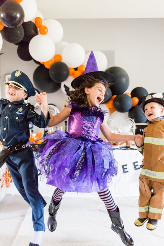kids dressed in Halloween costumes jumping 