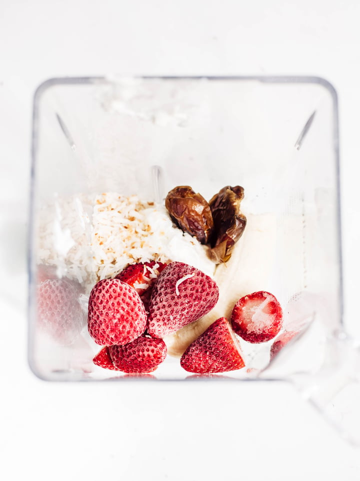 strawberries, shredded coconuts, banana, dates, and ice in a blender