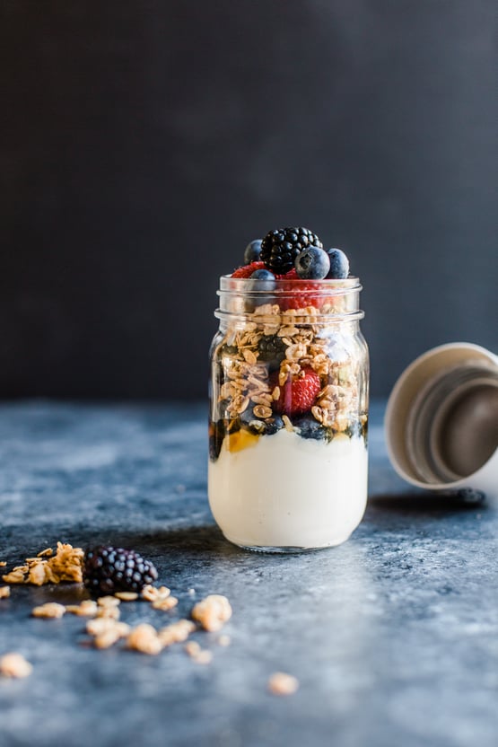 yogurt topped with granola in a mason jar with berries