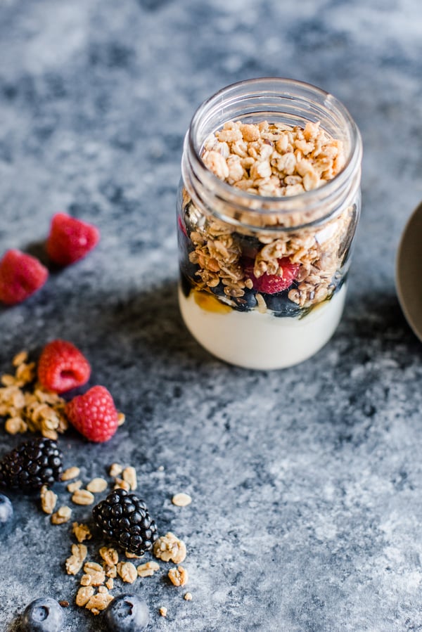 yogurt topped with granola in a mason jar with berries