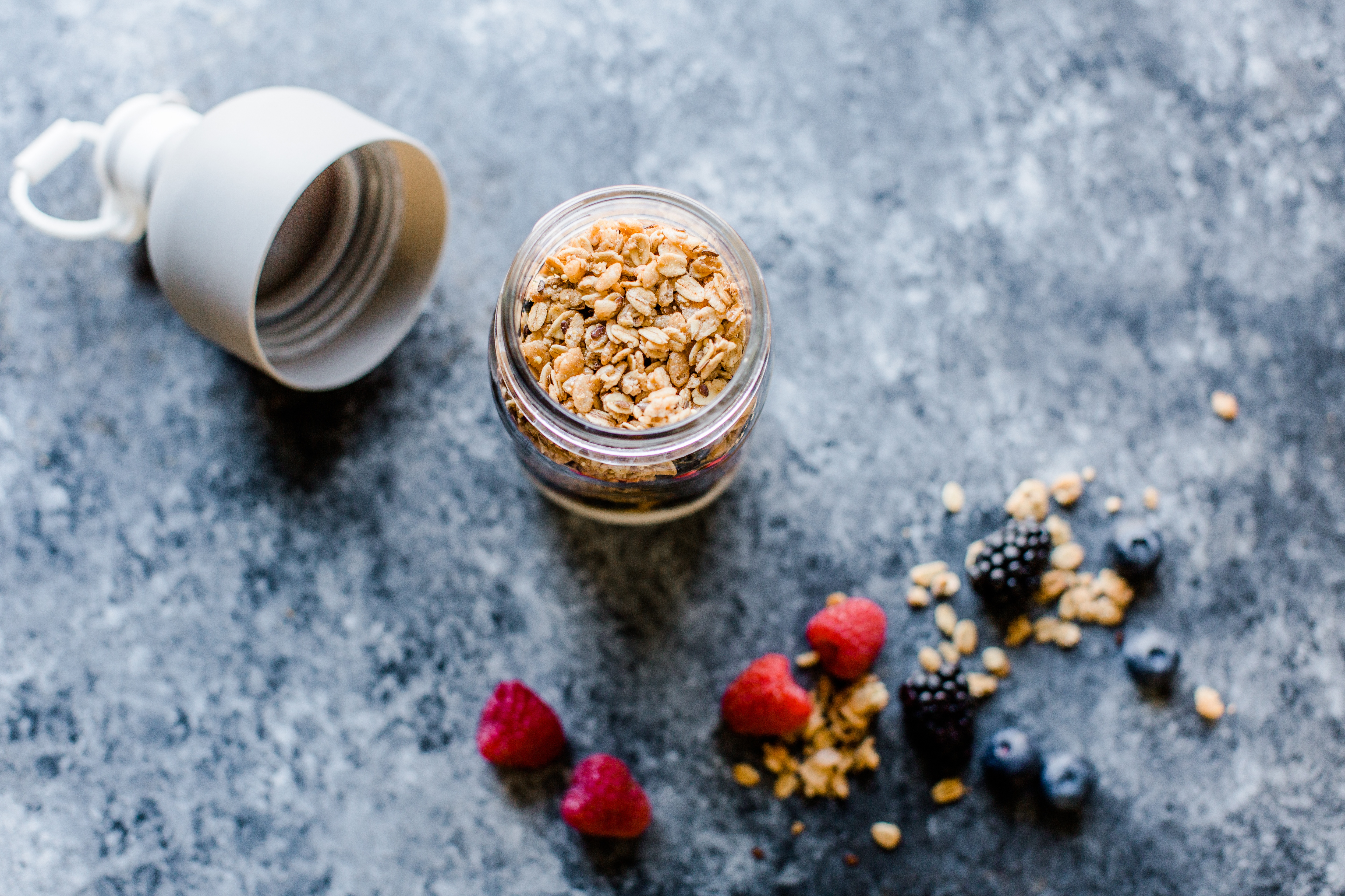 yogurt topped with granola in a mason jar with berries on the side of the jar