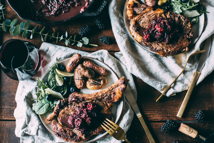 table spread of steaks with blackberry sauce 