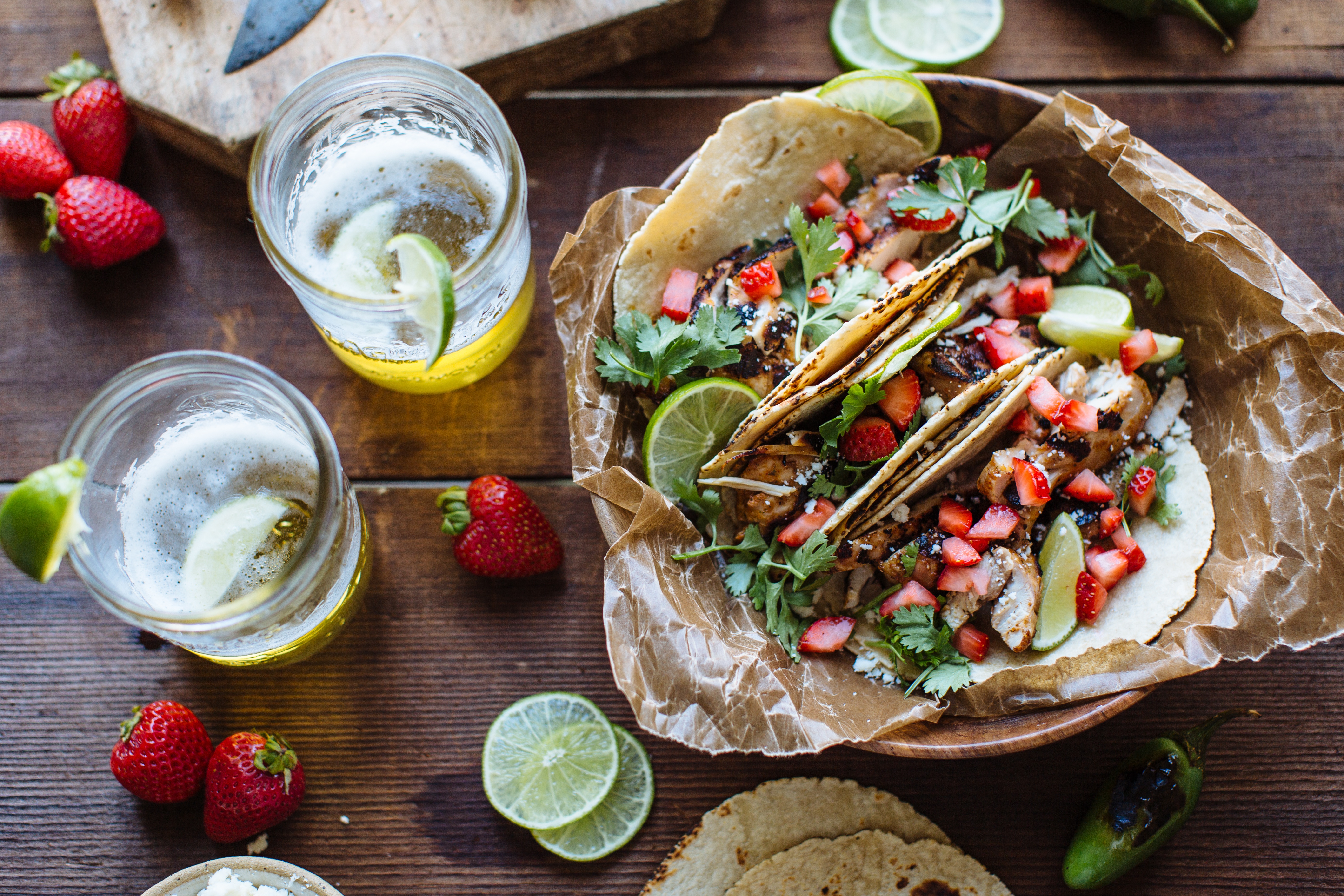 chicken tacos topped with diced strawberries, cilantro, and a wedge of lime