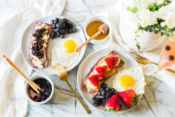 sweet potato toast topped with berries and a side of eggs