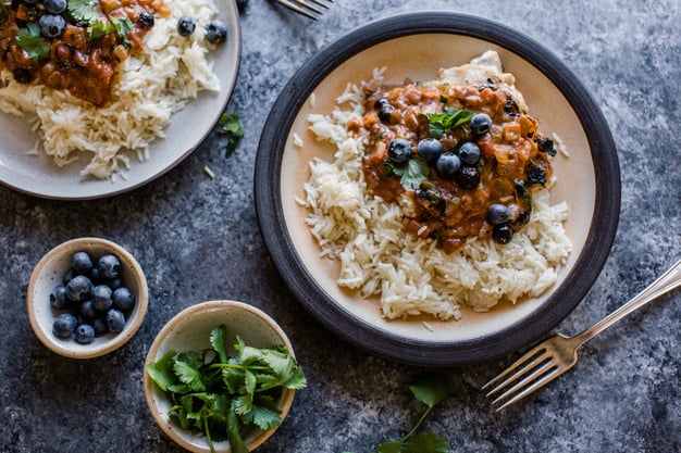 tikka masala on rice topped with blueberries