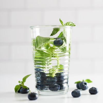 blueberries and basil leaves in a glass of water